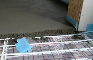 Photo - Pouring concrete screed onto a heated floor pipeline