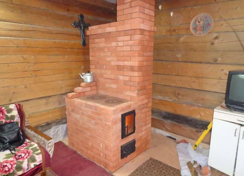 A brick stove with a hob protruding from the left side