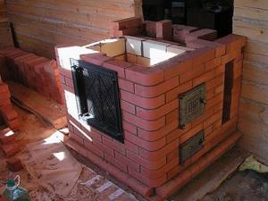 Wall-mounted brick stove in a wooden house