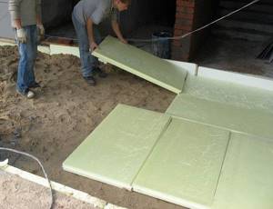 Laying insulation boards on a sand bed